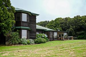 a house with a green roof and a yard at Macksville Cottage Robertson in Robertson