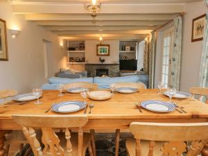 a wooden table with plates and wine glasses on top at Trenouth Cottage in Padstow