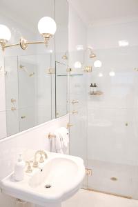 a white bathroom with a sink and a shower at Macksville Cottage Robertson in Robertson +17 photos