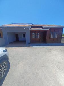 a house with a car parked in front of it at Casa Barra do Sai in Itapoa