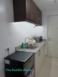 a kitchen with a sink and a microwave at The Humble Abode in Tagaytay