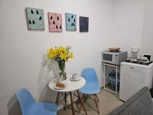 a table with blue chairs and a vase of flowers at Mono Espacio en Zona Romántica L3 in Puerto Vallarta