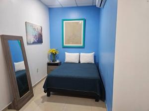 a blue room with a bed and a mirror at Mono Espacio en Zona Romántica L3 in Puerto Vallarta