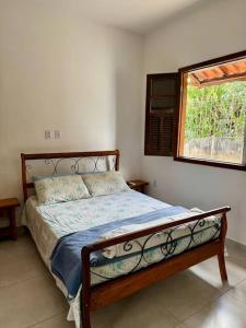 ein Bett in einem Schlafzimmer mit einem Fenster und einem Bett sidx sidx sidx in der Unterkunft Casa Azul da Bocaina em São José do Barreiro in São José do Barreiro