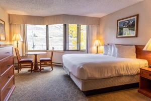 a hotel room with a bed and a table with chairs at Studio Perfect Location 318 with Pool and Hot Tub in Crested Butte