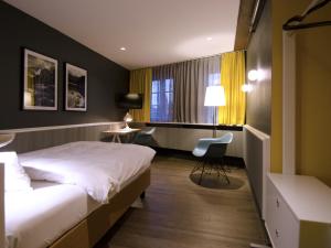 a hotel room with a bed and a desk and a window at Hotel Scholl in Schwäbisch Hall