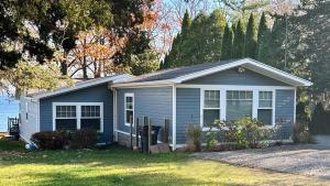 ein kleines blaues Haus im Gras in der Unterkunft The Blue Bungalow, Seneca Lake in Penn Yan
