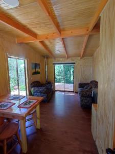 ein Wohnzimmer mit einem Tisch und Stühlen in einem Zimmer in der Unterkunft Entre Aromos in Lago Ranco