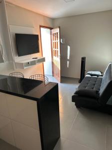 a living room with a couch and a flat screen tv at Portal Araticum Flats in Bonito