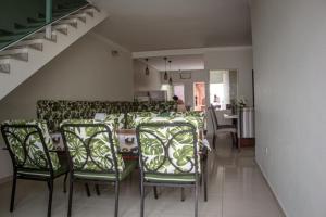 a dining room with green chairs and a table at Casa B de veraneio com estacionamento fechado in Ilha Comprida