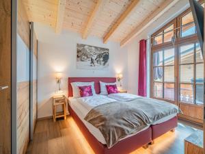 a bedroom with a bed and a large window at Petras Chalet-Apartment am Lift in Rauris