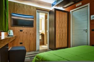 um quarto com uma cama e uma televisão na parede em Hotel Angioino & Spa em Nápoles mais 65 fotografias