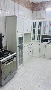 a kitchen with white cabinets and a stove top oven at شقة رائعة لسياحة في جازان in Jazan +8 photos