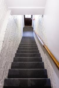a stairway leading up to a door in a building at West Broadway Quarters by Thatch in Boston