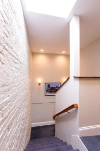 a hallway with a stone wall and stairs at West Broadway Quarters by Thatch in Boston