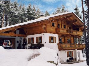 a log house in the snow with a balcony at Apartment Westermeyr in Mieming