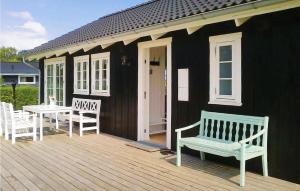 a black house with a bench and a table on a deck at Holiday Home Sønderbygade Sydals Vi in Kegnæshøj +12 photos