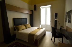 a bedroom with a bed and a desk and a window at Alvino Suite And Breakfast in Lecce