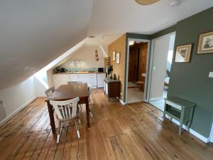una sala da pranzo con un tavolo e una cucina di Sous les toits de la Tavarn Ty Gar a Hennebont