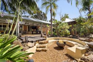 a garden with a fire pit in front of a house at Dandjoo - hot tub, fire pit, outdoor entertainment in Dunsborough