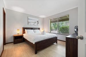 a bedroom with a large bed and a window at Dandjoo - hot tub, fire pit, outdoor entertainment in Dunsborough