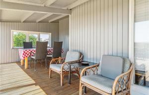 una sala da pranzo con sedie, tavolo, tavolo e sedie a sdraio di Three-Bedroom Holiday Home In Ebeltoft a Ebeltoft