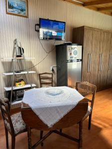 eine Küche mit einem Tisch, einem Kühlschrank und einem TV in der Unterkunft Donde la Nana in Punta Arenas