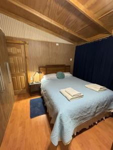 ein Schlafzimmer mit einem Bett mit zwei Handtüchern darauf in der Unterkunft Donde la Nana in Punta Arenas