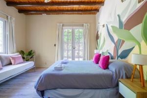 a bedroom with a large bed with pink pillows at Fliphaus Chacras De Coria - 4 Bd House Pool&bbq in Ciudad Lujan de Cuyo +19 photos