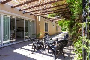a patio with chairs and a wooden pergola at Fliphaus Chacras De Coria - 4 Bd House Pool&bbq in Ciudad Lujan de Cuyo