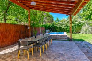 a patio with a table and chairs and a pool at Fliphaus Chacras De Coria - 4 Bd House Pool&bbq in Ciudad Lujan de Cuyo