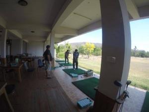 two men playing ping pong in a room with green mats at Hotel Golf 19 in Ban Hua Khao