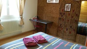 sypialnia z 2 fioletowymi ręcznikami na łóżku w obiekcie Le Clos des Meix w mieście Lanthes