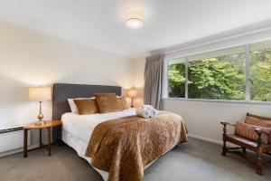 a bedroom with a bed with a teddy bear on it at Central Arrowtown - 4 Beds and Hot Tub! in Arrowtown