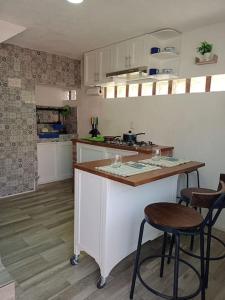 a kitchen with two bar stools and a counter top at Casita azul in Morelia
