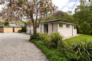 a house with a gravel driveway in front of it at Central Arrowtown - 4 Beds and Hot Tub! in Arrowtown