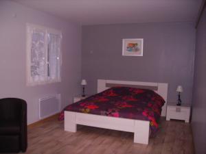 a bedroom with a bed with a red blanket at La Grimodière in Ranville +18 photos