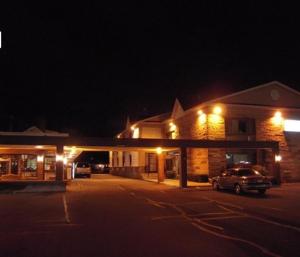 ein Auto, das nachts vor einem Gebäude parkt in der Unterkunft Colonie Inn and Suites in Latham