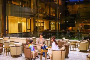 a group of people sitting in chairs in a lobby at Ooedo Onsen Monogatari Premium Hotel Sokan in Matsushima