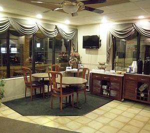 uma sala de jantar com mesa e cadeiras e uma televisão em Colonie Inn and Suites em Latham