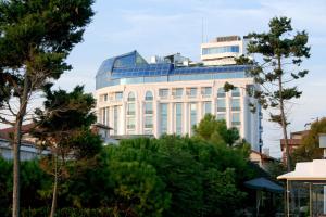 a tall white building with blue windows at Eser Premium Hotel & Spa in Büyükçekmece