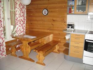 eine Küche mit einem Holztisch und einer Bank in der Unterkunft Koli Country Club in Kolinkylä