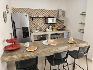 eine Küche mit einer Theke mit Teller mit Lebensmitteln darauf in der Unterkunft Hermoso Apartamento 2 recámaras L4 in Puerto Vallarta