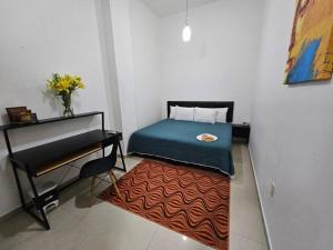 Schlafzimmer mit einem Bett, einem Tisch und einem Teppich in der Unterkunft Hermoso Apartamento 2 recámaras L4 in Puerto Vallarta