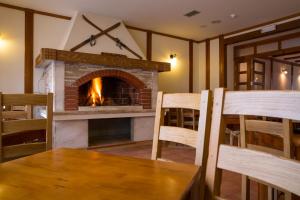 ein Wohnzimmer mit einem Kamin, einem Tisch und Stühlen in der Unterkunft Hotel Knez in Kupres