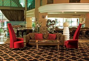 a lobby with a couch and two red chairs at Eser Premium Hotel & Spa in Büyükçekmece +62 photos