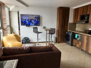 ein Wohnzimmer mit einer Couch und einem Fernseher an der Wand in der Unterkunft Laureles Penthouse rooftop Suite in Medellín + 8 Fotos