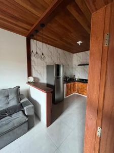 a kitchen with a stainless steel refrigerator and a couch at Casa Almeida in Tiradentes