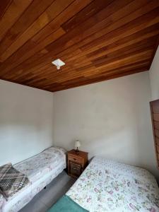 a bedroom with two beds and a wooden ceiling at Casa Almeida in Tiradentes