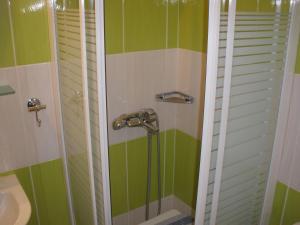 a bathroom with green and white walls and a shower at Pelias Hotel in Portariá